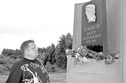 Андрей Гладков у дорожной стелы с барельефом деда