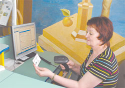 Библиотекарь Центральной детской библиотеки Валентина Радке считывает информацию с электронного читательского билета;  Фото автора